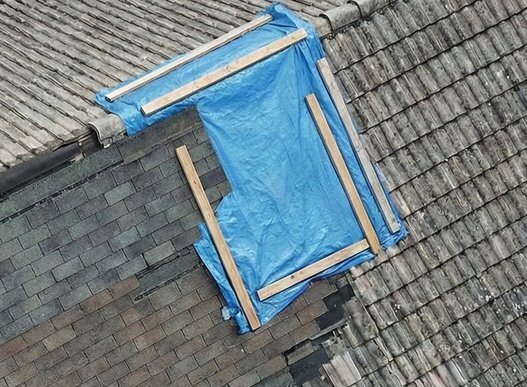 High-resolution drone image showing an unauthorized roof patch repair - Uncertified roof work 10 year rule